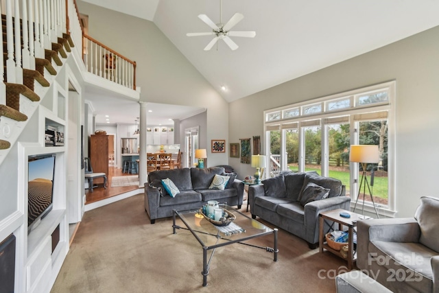 living room with high vaulted ceiling, ceiling fan, and carpet