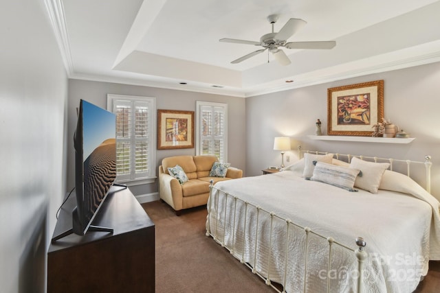 carpeted bedroom with crown molding, ceiling fan, and a tray ceiling