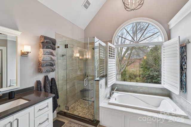 bathroom featuring independent shower and bath, vanity, vaulted ceiling, and an inviting chandelier