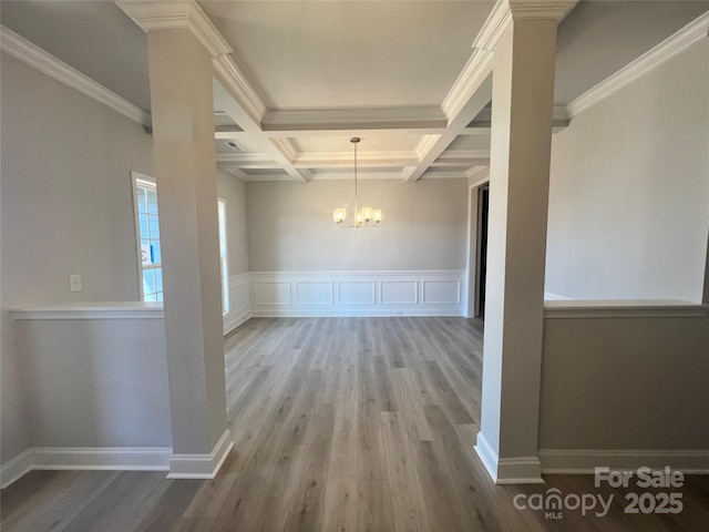 interior space with beamed ceiling, coffered ceiling, wood finished floors, and a notable chandelier