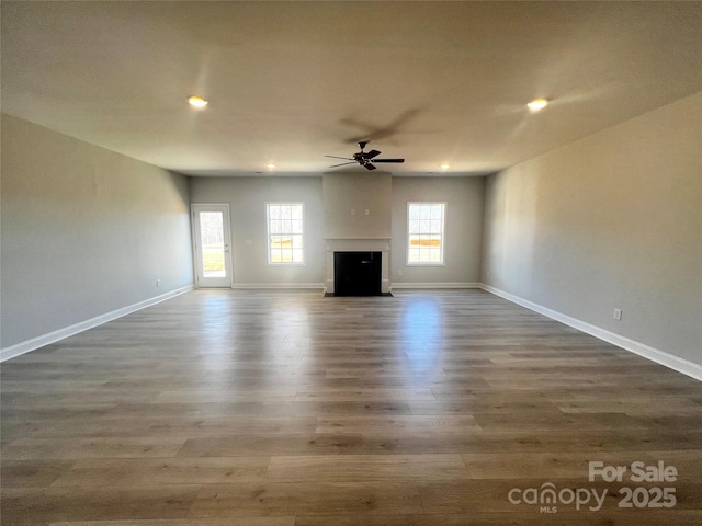 unfurnished living room featuring recessed lighting, a fireplace, a ceiling fan, baseboards, and dark wood-style floors