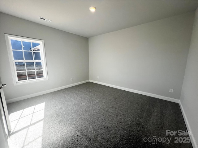 spare room with baseboards, visible vents, and carpet flooring