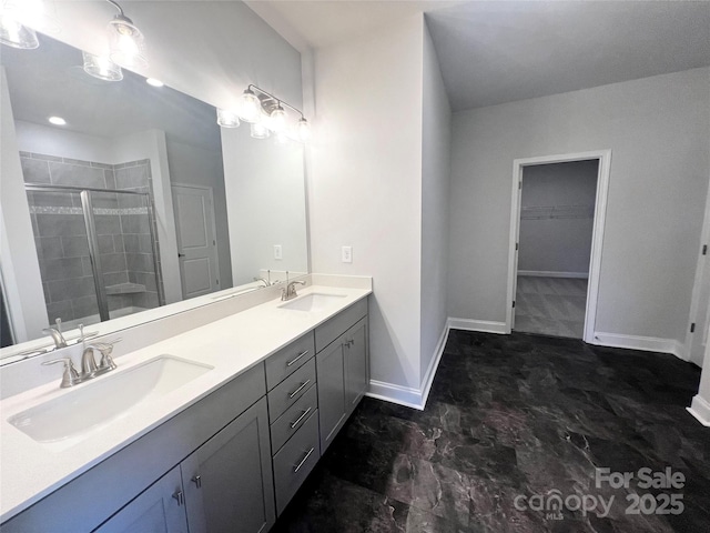 bathroom featuring double vanity, a sink, a walk in closet, and a shower stall