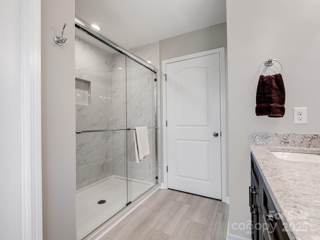 bathroom featuring vanity and a marble finish shower