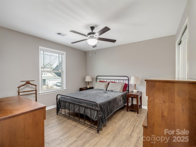 bedroom featuring visible vents, light wood-style flooring, a ceiling fan, and baseboards