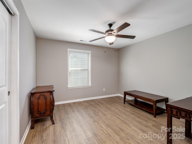 interior space with ceiling fan, light wood-style floors, visible vents, and baseboards