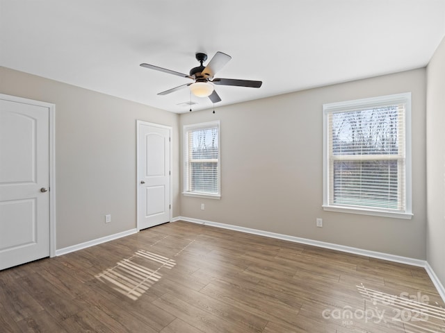 unfurnished bedroom featuring ceiling fan, baseboards, and wood finished floors