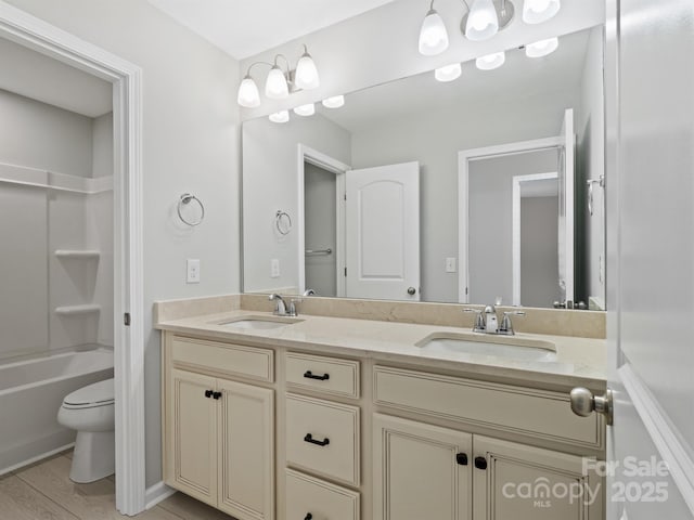 bathroom with a sink, shower / bathtub combination, toilet, and double vanity