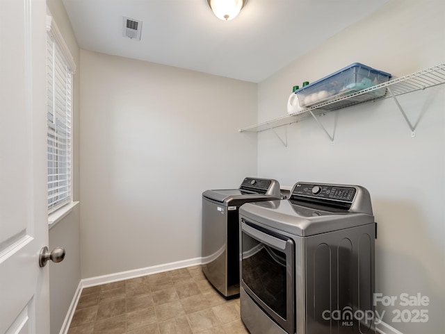 laundry room featuring laundry area, washing machine and dryer, visible vents, and baseboards