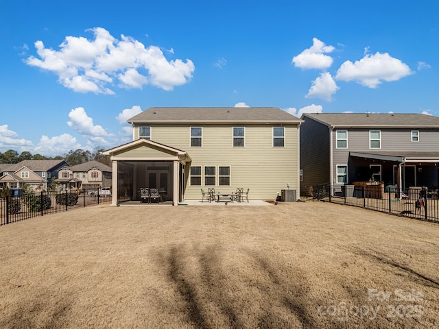 rear view of house featuring central air condition unit, a sunroom, a fenced backyard, and a patio area