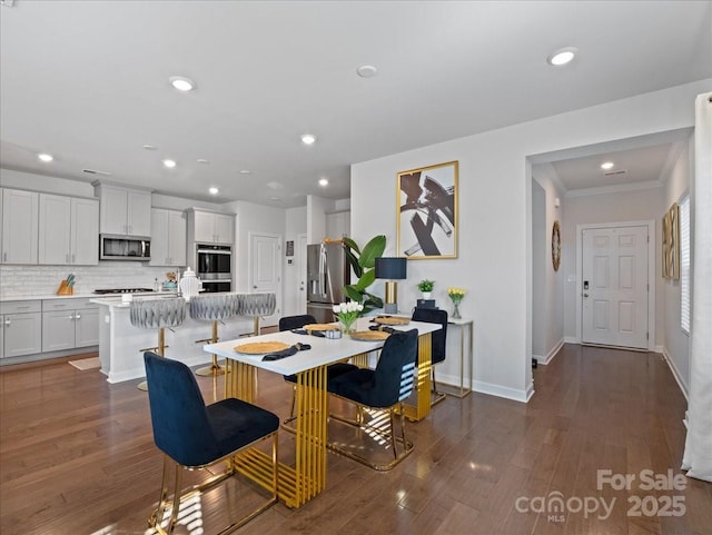 dining space with crown molding and dark hardwood / wood-style flooring