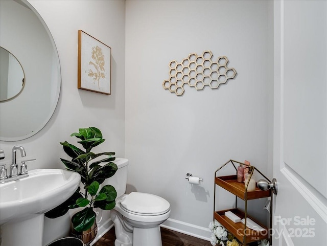 bathroom featuring hardwood / wood-style flooring, toilet, and sink