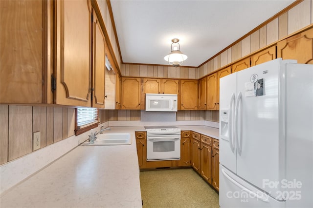 kitchen with crown molding, white appliances, and sink