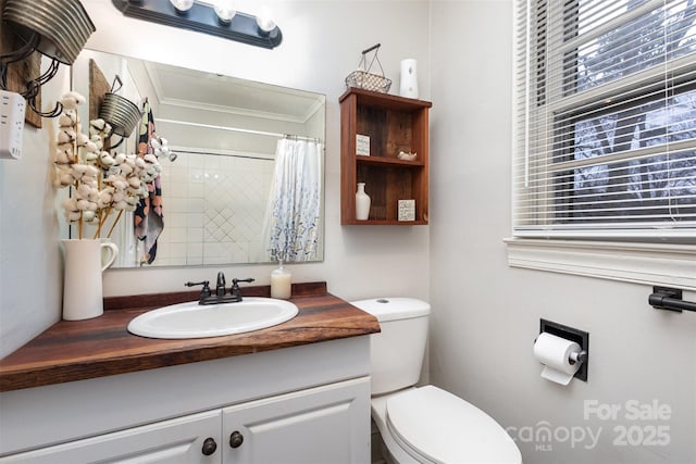 bathroom with a shower with curtain, ornamental molding, vanity, and toilet