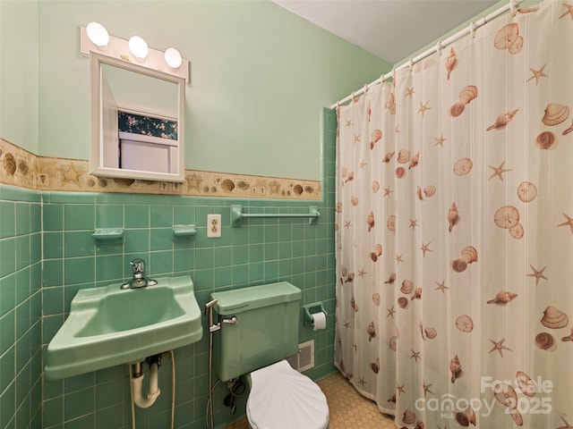 bathroom with toilet, sink, tile walls, and a shower with shower curtain