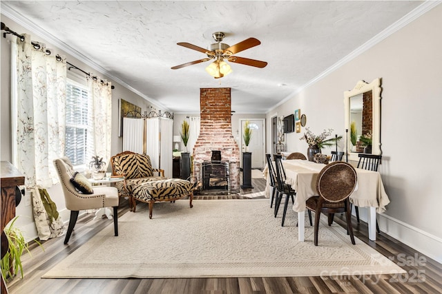 dining area featuring a textured ceiling, wood-type flooring, ornamental molding, and ceiling fan