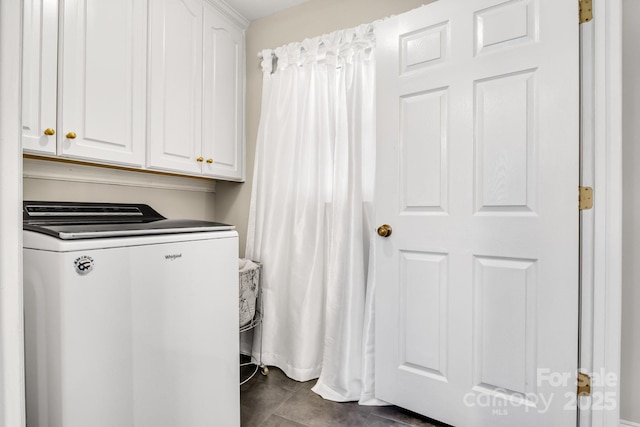 clothes washing area featuring washer / clothes dryer and cabinets