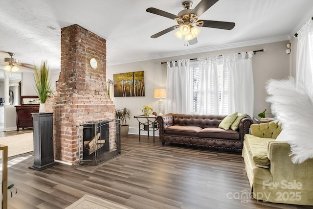 living room with crown molding, ceiling fan, dark hardwood / wood-style flooring, and a brick fireplace