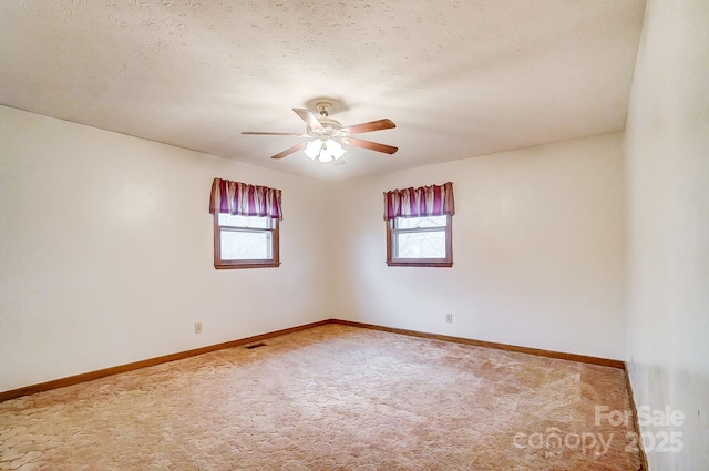 spare room featuring plenty of natural light, light colored carpet, and ceiling fan