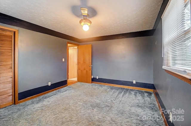 unfurnished bedroom featuring carpet floors, a closet, and a textured ceiling