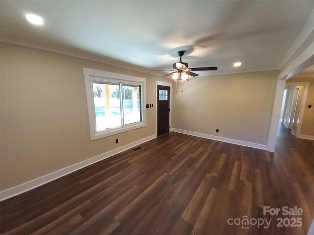 unfurnished room with dark wood-type flooring, ceiling fan, and crown molding