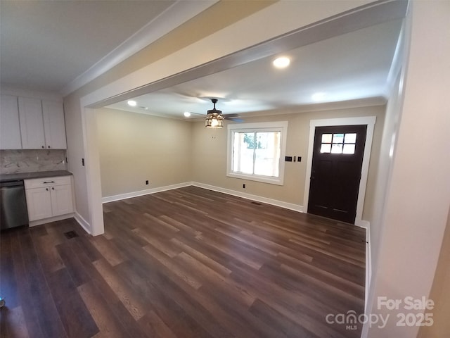 foyer with crown molding, dark wood-type flooring, and ceiling fan