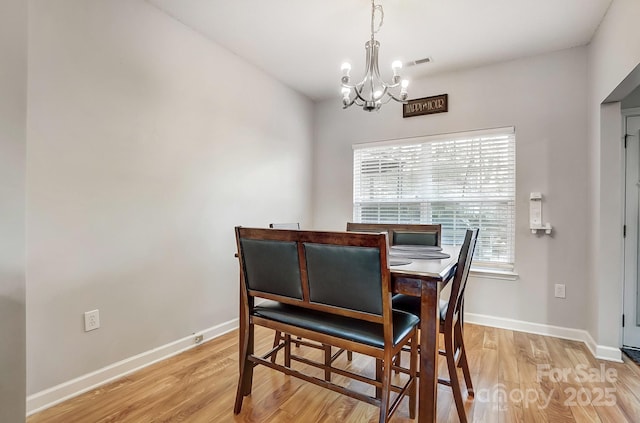 dining space featuring a notable chandelier and light hardwood / wood-style flooring