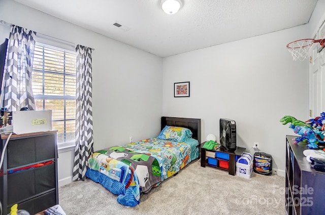 bedroom with carpet floors and a textured ceiling