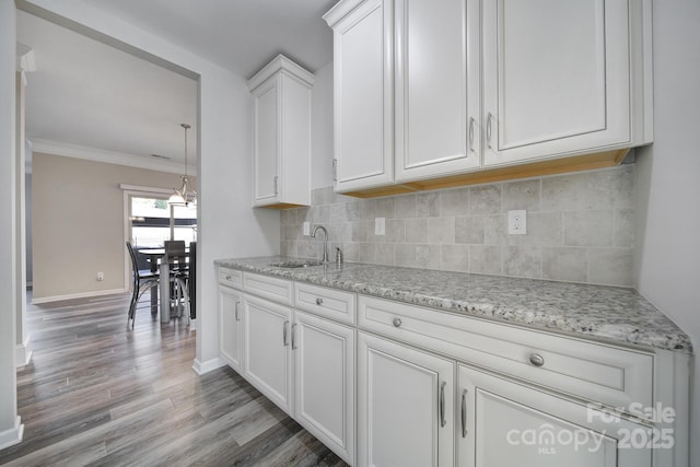 kitchen featuring white cabinets, sink, and tasteful backsplash