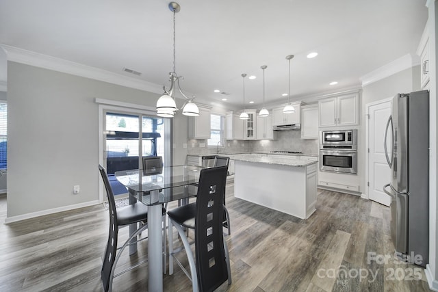 dining area with dark wood-type flooring and crown molding