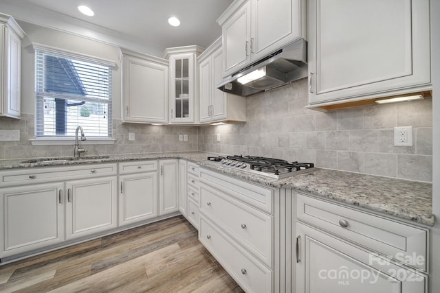 kitchen with sink, white cabinets, stainless steel gas stovetop, and light hardwood / wood-style flooring