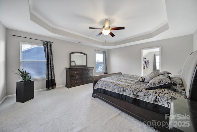 bedroom with a raised ceiling, crown molding, light carpet, and ceiling fan