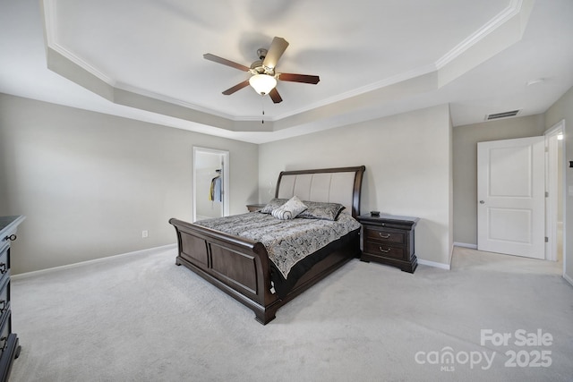 carpeted bedroom with a tray ceiling, ornamental molding, and ceiling fan