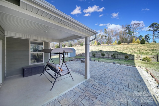 view of patio with a storage unit and an outdoor fire pit