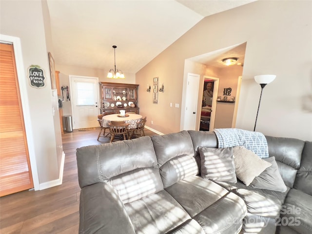 living room with lofted ceiling, dark hardwood / wood-style floors, and a notable chandelier