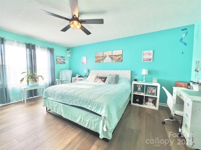 bedroom with hardwood / wood-style floors, a textured ceiling, and ceiling fan