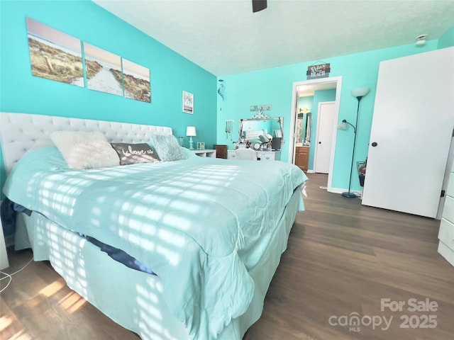 bedroom featuring ceiling fan, ensuite bathroom, and dark hardwood / wood-style flooring