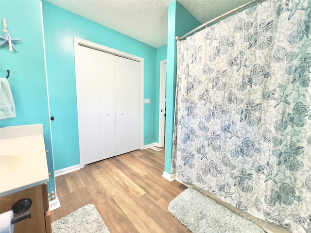 bathroom featuring vanity, hardwood / wood-style flooring, a textured ceiling, and a shower with shower curtain