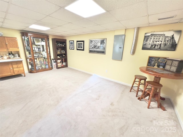 basement with light colored carpet and a drop ceiling