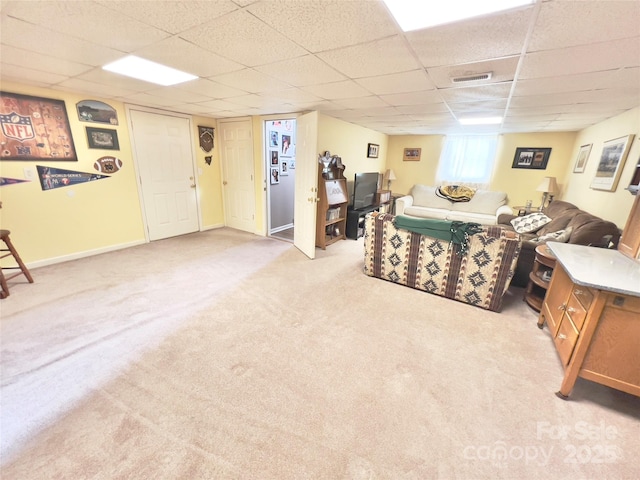 living room with a paneled ceiling and light colored carpet