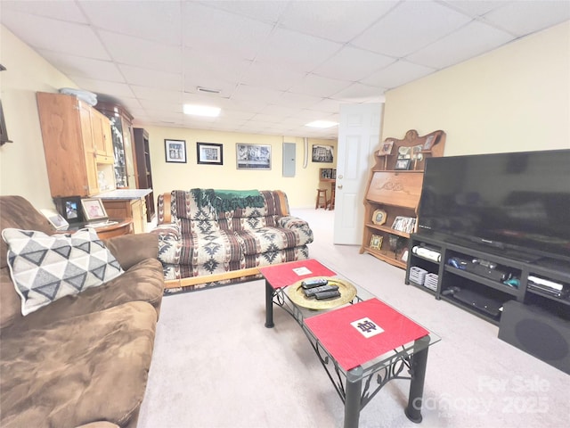 carpeted living room with a drop ceiling