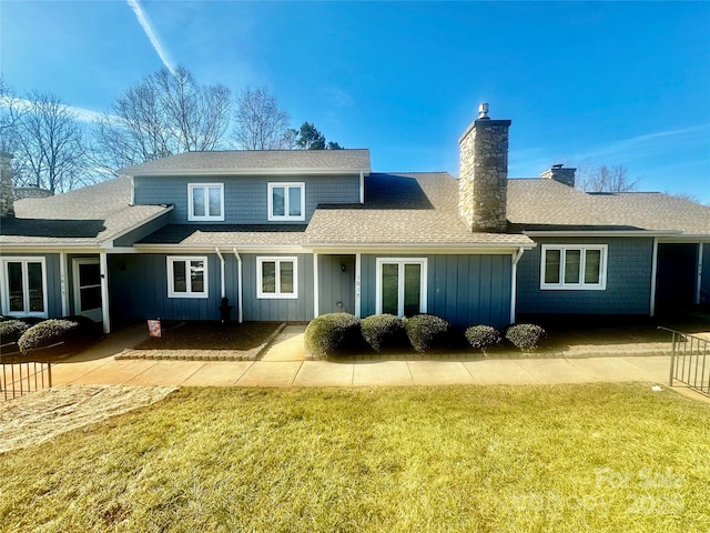 rear view of property featuring a lawn