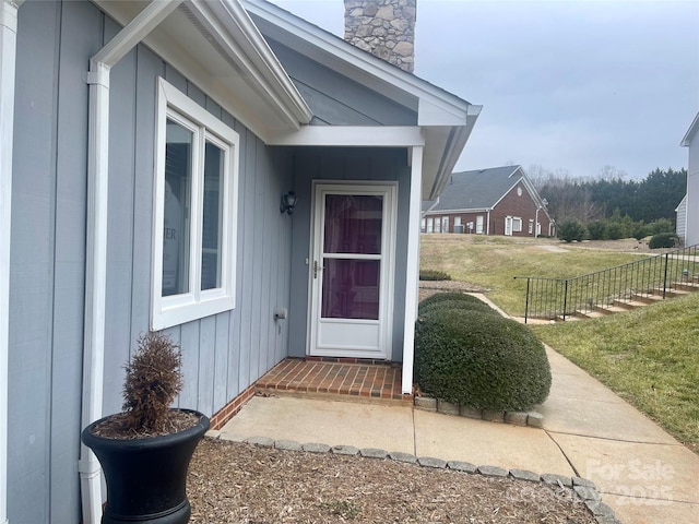 property entrance featuring a lawn