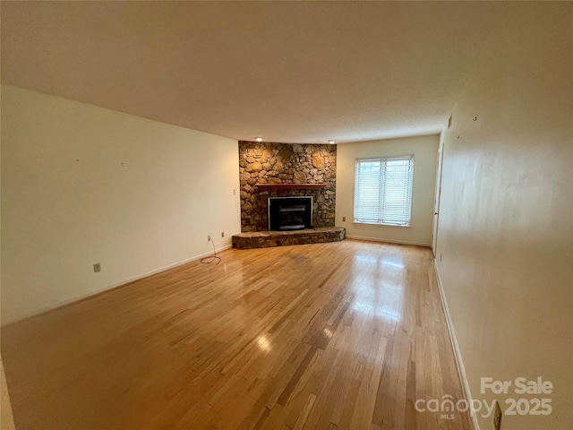 unfurnished living room with hardwood / wood-style flooring and a fireplace