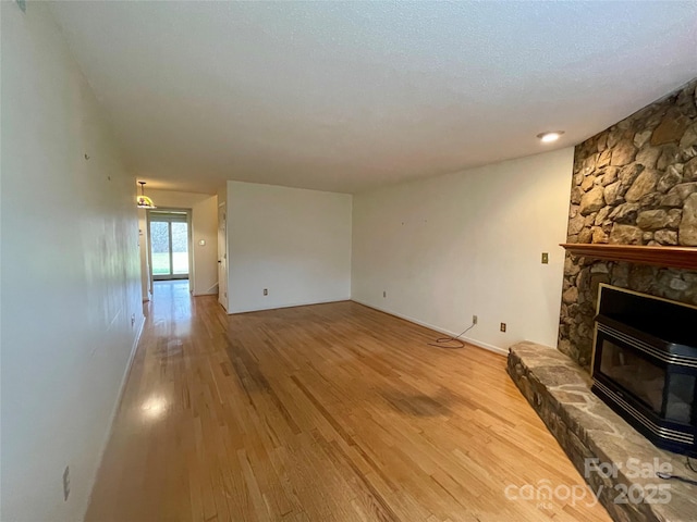 unfurnished living room with hardwood / wood-style flooring, a fireplace, and a textured ceiling