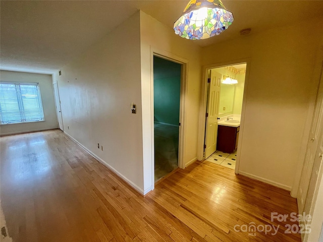 corridor featuring sink and light hardwood / wood-style flooring