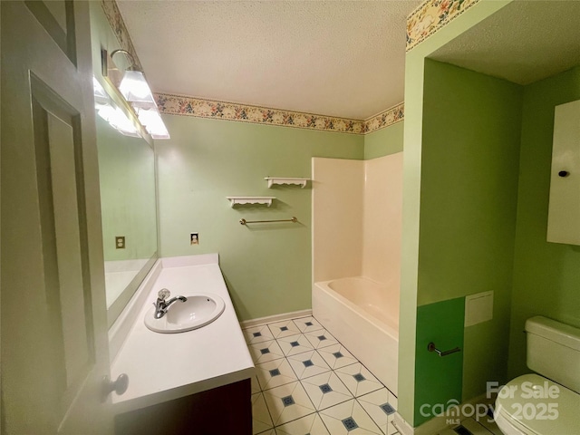 bathroom with vanity, a textured ceiling, and toilet