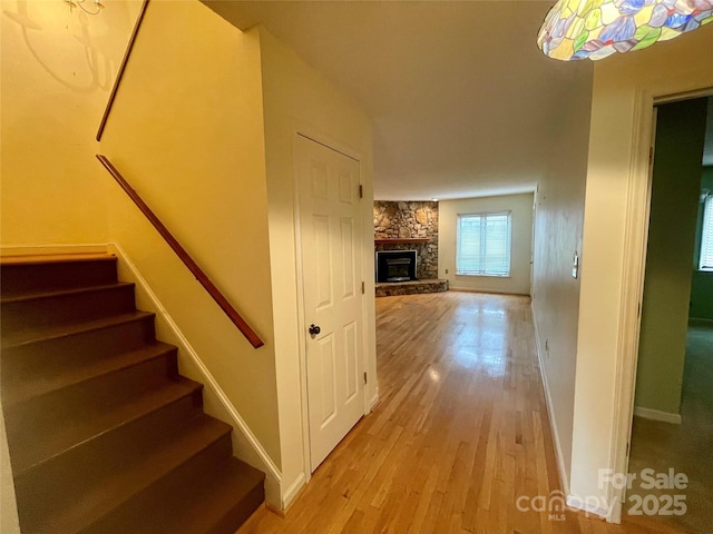 stairs featuring a fireplace and wood-type flooring