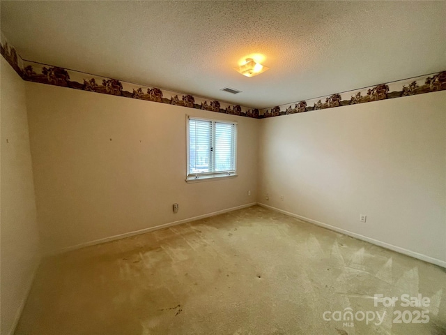 unfurnished room featuring carpet and a textured ceiling