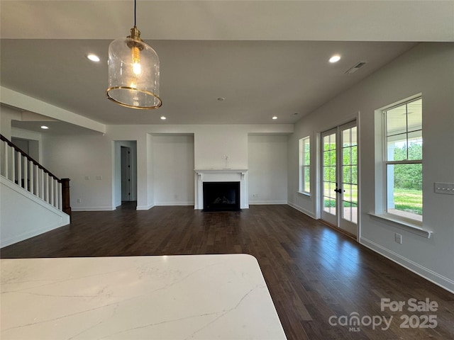 unfurnished living room with dark wood finished floors, baseboards, visible vents, and recessed lighting